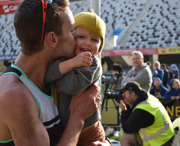 Inkster-Baynes kisses daughter Indi (3) after winning the national half marathon title.