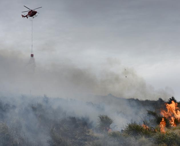 A helicopter drops water on to the Flagstaff fire in Dunedin yesterday.