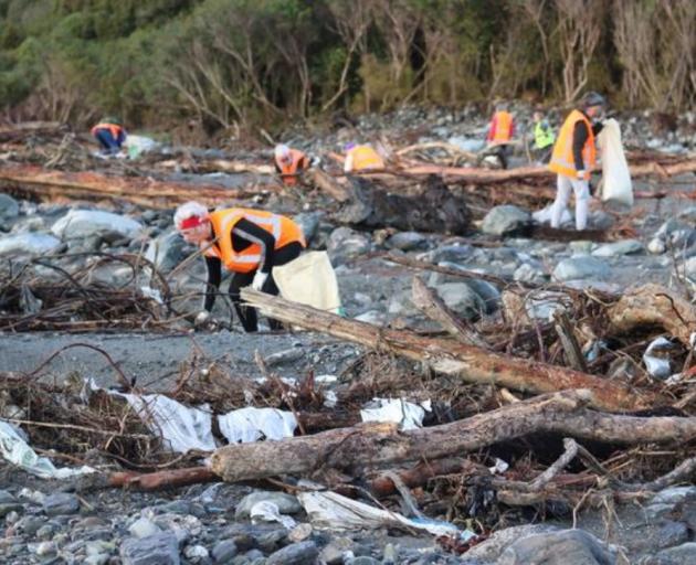 Volunteers pick up rubbish where a disused Fox River landfill spilled litter on the West Coast...
