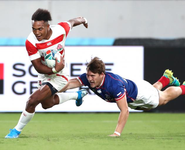 Hat-trick hero Kotaro Matsushima of Japan glides past a Russian defender on his way to the try...