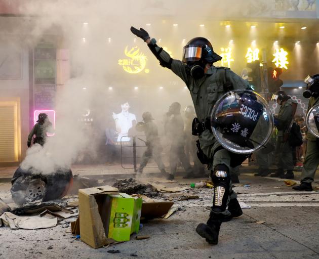 Riot police walk next to a street barricade during a demonstration in Mong Kok district in Hong Kong. Photo: Reuters