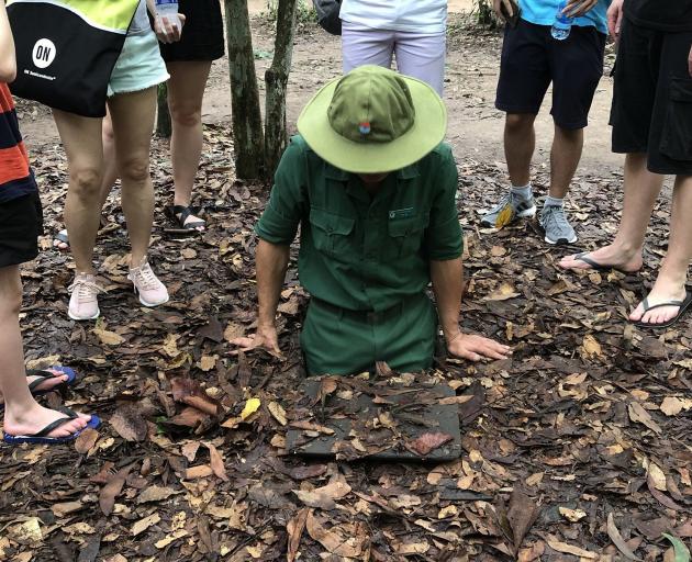 A guide lowers himself into the Cu Chi Tunnels. Photo: Supplied.
