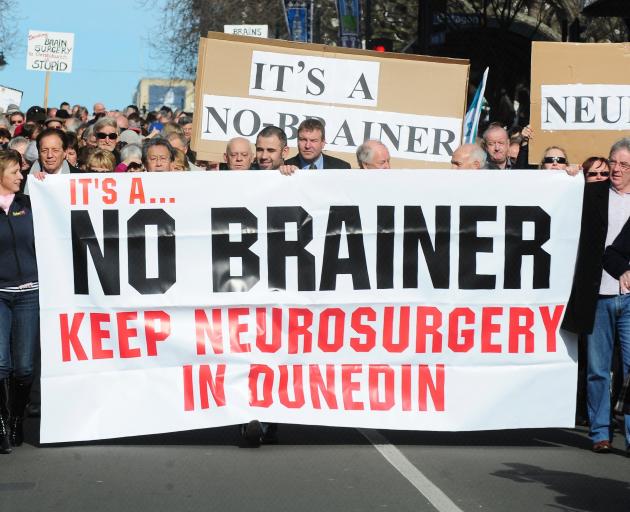 Marchers hold up a signs during a protest to keep neurosurgery services in Dunedin. Photo: ODT files