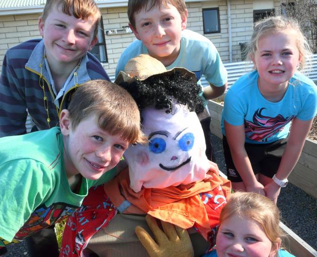Tahakopa School pupils (clockwise, from left) Clark (9) and Alex Napier (11), Braydee Osborne (12), Sarah Stephens (11), and Jacquelyn Barrett (7), and their Balclutha Community Garden scarecrow competition entry Betsy-Shirley. Photo: Richard Davison