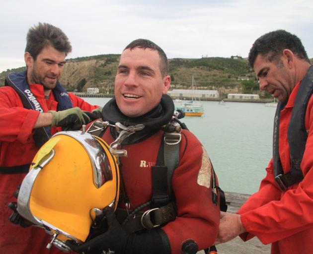 Bays Underwater Services crew members Sjors Hoogenboom (left) and John McLaren (right) assist Mr...