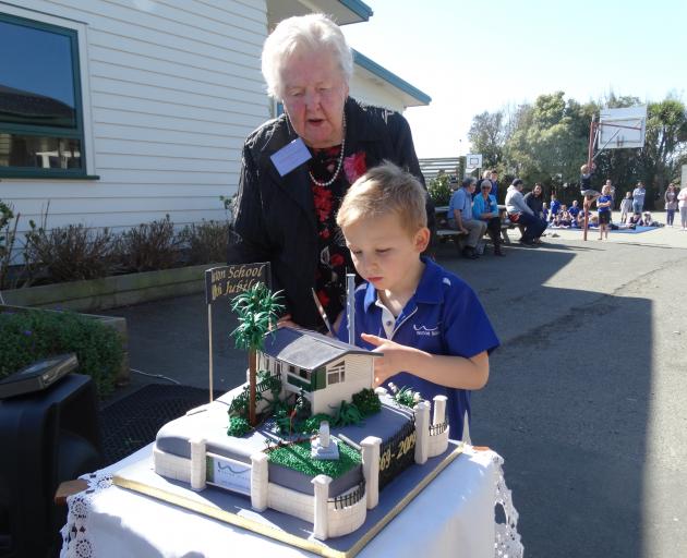 Former Weston School pupil Joan Martin (90) and pupil Hugh Newton (5) cut a cake at the school's 150th jubilee on Saturday. Photo: Daniel Birchfield