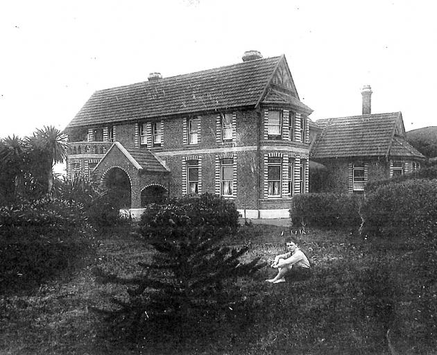 A young boy - possibly the Shiels' youngest son, Robert - sits in the grounds in this undated...