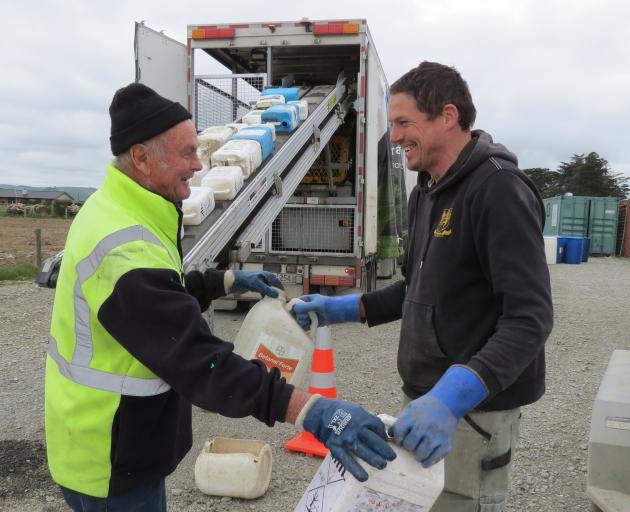 Agrecovery contractor Rodger Gregge (left), of Ashburton, collects chemical containers from Kuana farmer John Officer, during the "one-stop shop'' pilot rural waste management event at Limehills last week. Mr Gregge then put the containers on a conveyor b