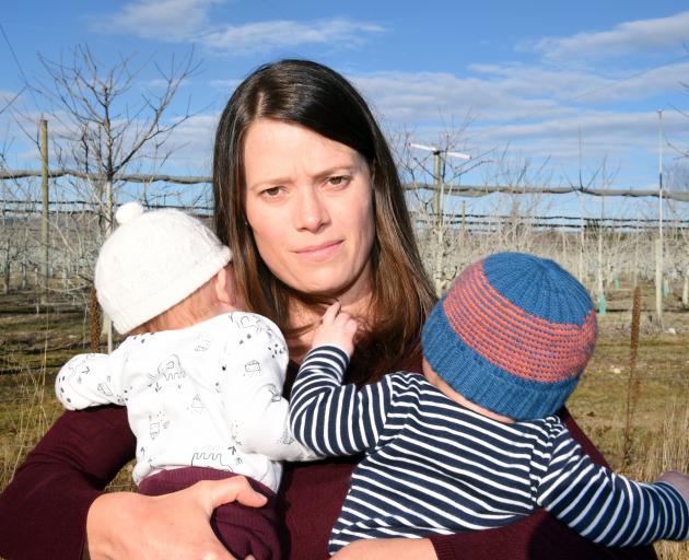 Katie Hill and her 3-month-old twins Chloe (left) and Zacon the boundary of her property near a noisy frost-fighting turbine. Photo: Gregor Richardson