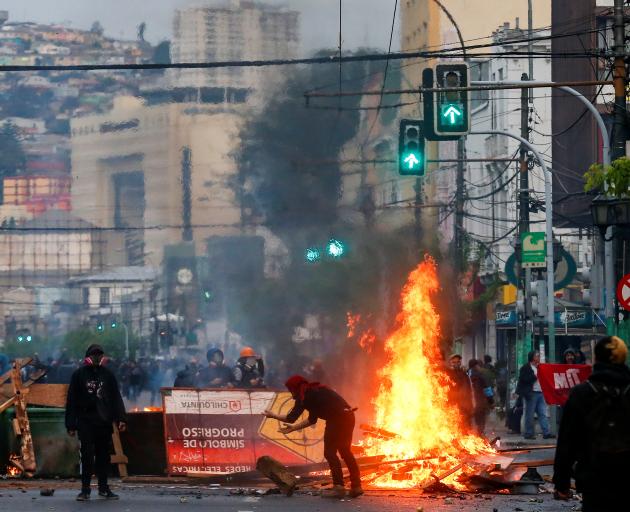 Demonstrators burn objects as they barricade a road during a protest against the government in...