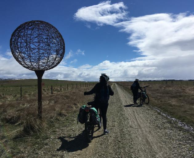 Cyclists admire a model of Jupiter installed near Wedderburn as one of nine planets in a scale...