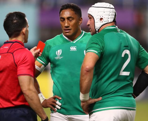 Referee Nic Berry holds up a red card to Ireland's Bundee Aki as captain Rory Best watches on....