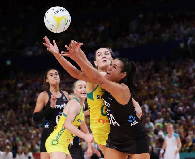 Ameliaranne Ekenasio of the Silver Ferns reaches for the ball under pressure from Courtney Bruce...