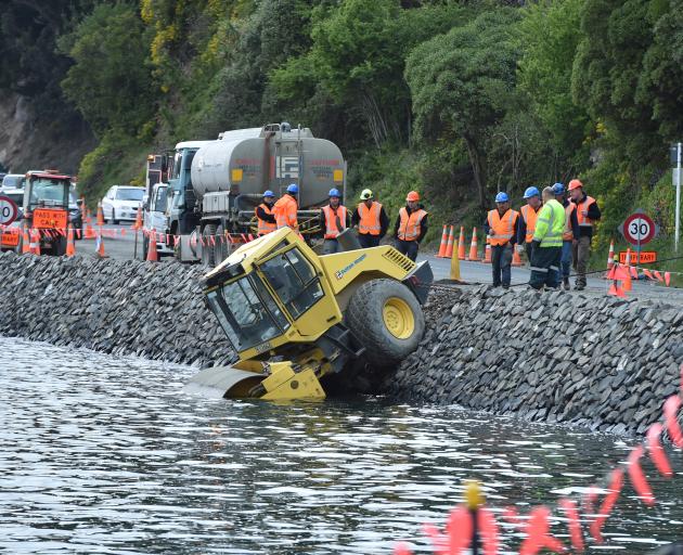 Fulton Hogan staff contemplate their next move after a roller ended up in Otago Harbour near the...