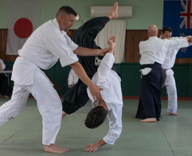 Scott McMurtrie, left, and Shayne Garbes, partially obscured, far right, during their successful 1st-degree black belt grading at the Rangiora Aikido Dojo. Photo: John Fahey
