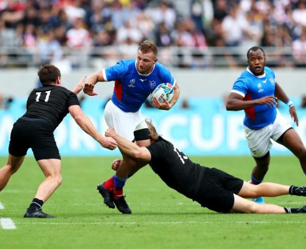 Namibia's Johan Tromp is tackled by Jack Goodhue and George Bridge during their Rugby World Cup...