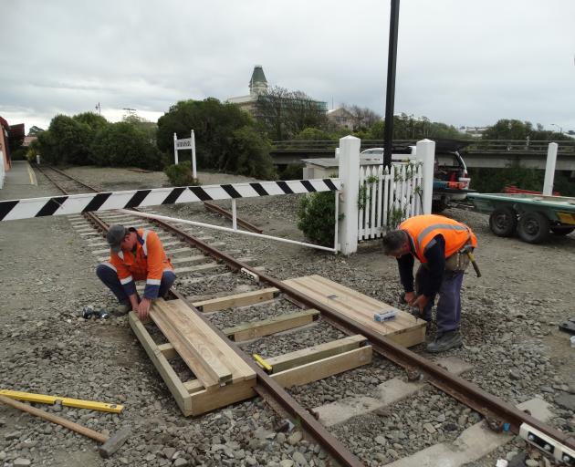Waitaki District Council contractors construct a wooden footbridge over a section of the Oamaru Steam and Rail Society’s track near Harbourside Station in Oamaru yesterday. Photo: Daniel Birchfield