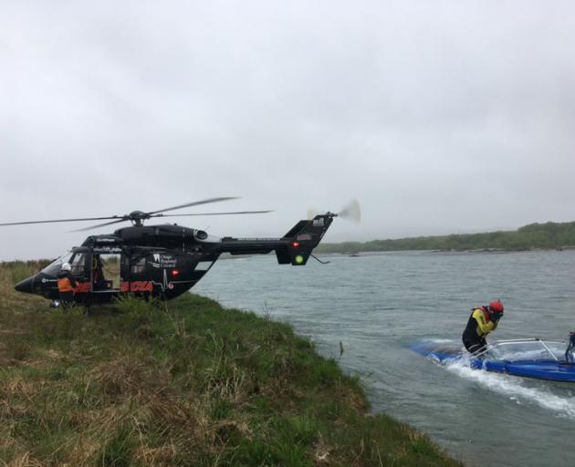 Rescue helicopter and search and rescue crew search the Waitaki River near Duntroon on Friday...