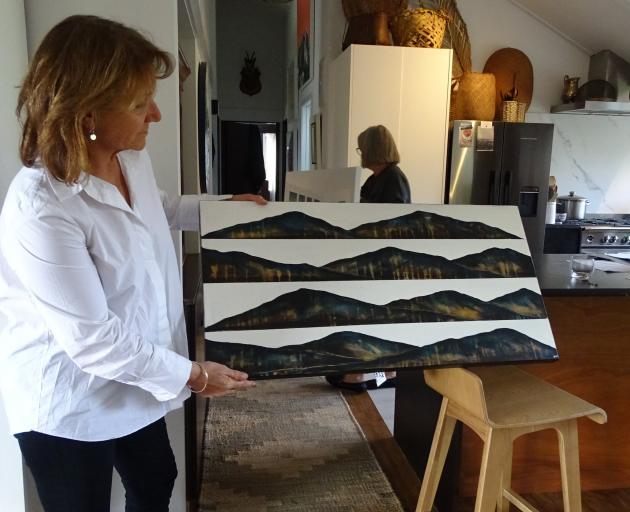 Wanaka Arts president Vicky Fulton holds one of the 200 works entered in this year’s exhibition....