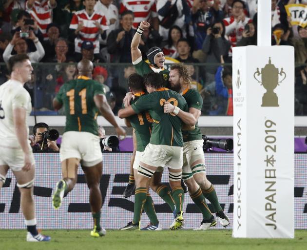 Cheslin Kolbe is enveloped by his teammates after scoring a late try that secured South Africa's...