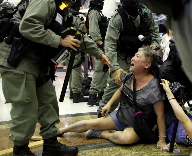 Riot police detain a woman during a protest at a shopping mall in Tai Po, Hong Kong. Photo: Reuters
