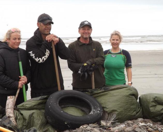 Kylie Coleman (left) and three of the other seven volunteers who worked together to pick up dead rats that washed up on a West Coast beach. Photo: Supplied/Kylie Coleman