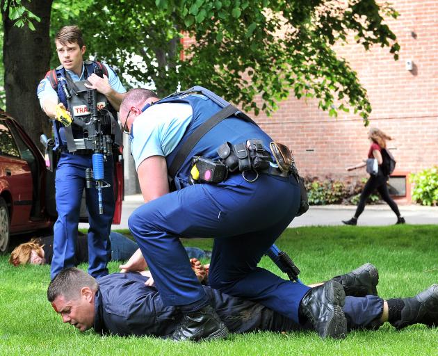 Simulating the apprehension of a criminal at the University of Otago as part of its emergency preparedness training exercise are (from left) volunteer Sonya Atkinson, Constable Adam Vanner, firefighter Simon Greenall and Constable Tim Coudret. Photo: Chri