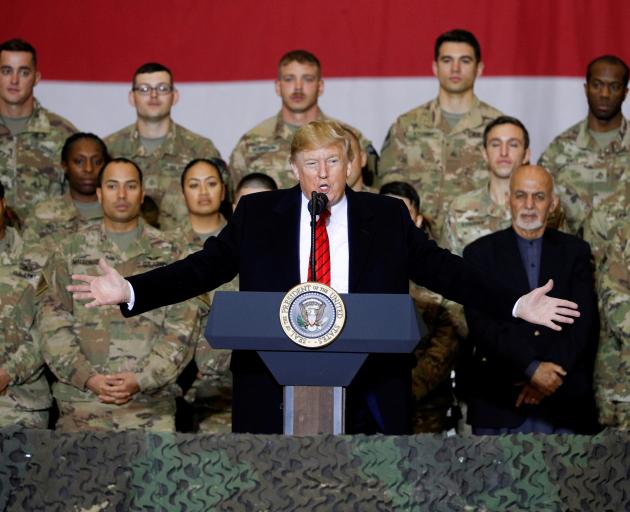 US President Donald Trump delivers remarks to US troops, with Afghanistan President Ashraf Ghani...