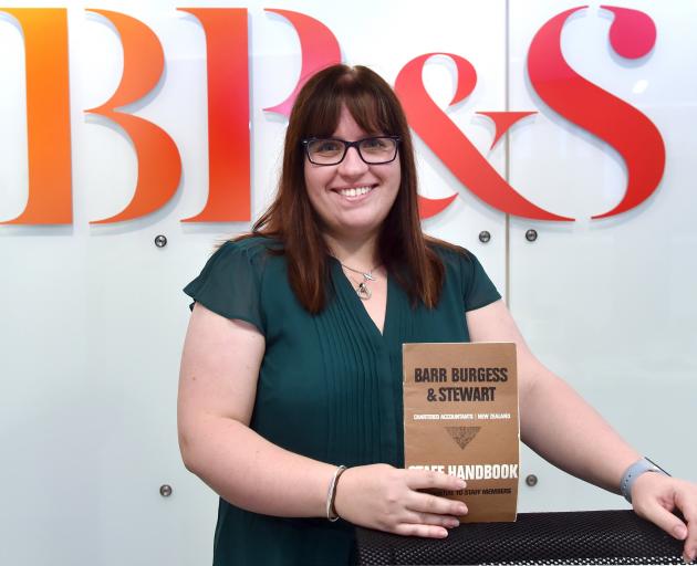 Barr Burgess and Stewart managing director Christine McNamara holds an old staff handbook. Photo: Peter McIntosh