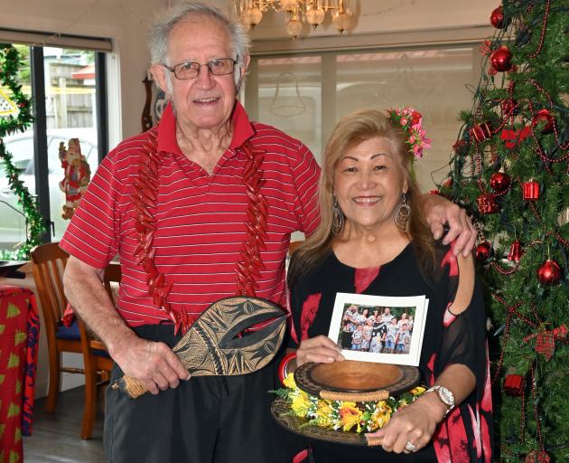Bob and Kara Cahill hold a Samoan tanoa kava bowl and a family picture by their Christmas tree. 
