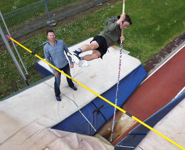 Cole Gibbons goes over the pole while his father and coach Paul watches at the Caledonian Ground yesterday. Photos: Gregor Richardson