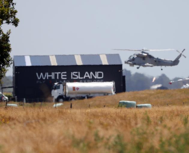 A military helicopter flies at the airport during the rescue mission following the White Island...