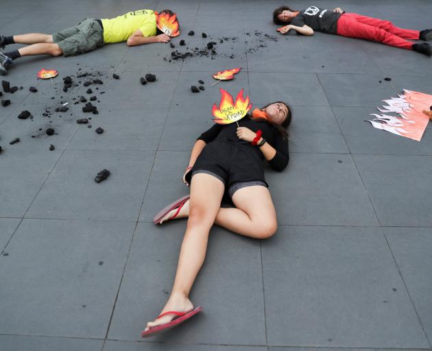 In Chile, protesters lay on the footpath during a demonstration outside the Australian embassy in...