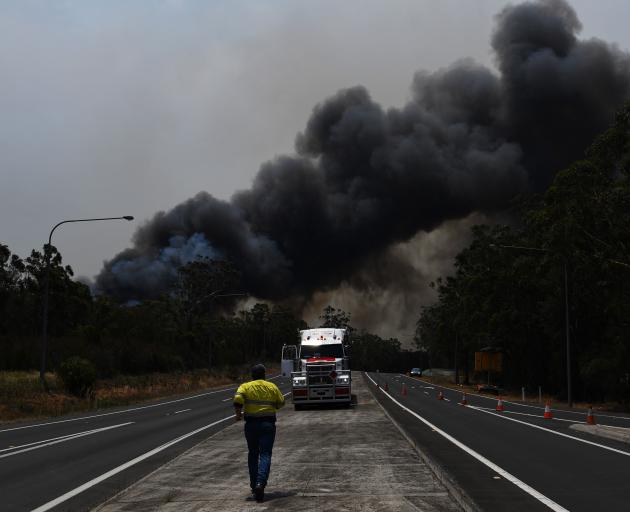 A truck driver prepares to move his vehicle through a roadblock bypass on the Princes Highway near the town of Sussex Inlet. Photo: Getty Images/ Sam Mooy