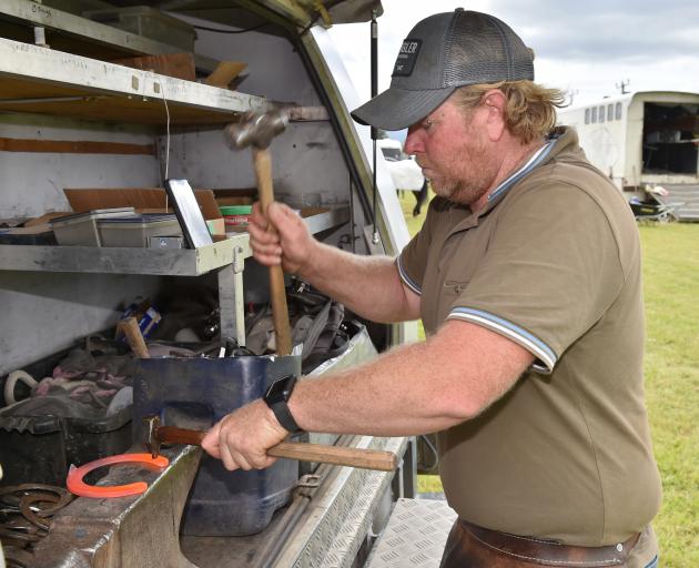 Farrier Jordan Dent, of Fairlie, prepares to replace a shoe for a horse competing in yesterday’s...