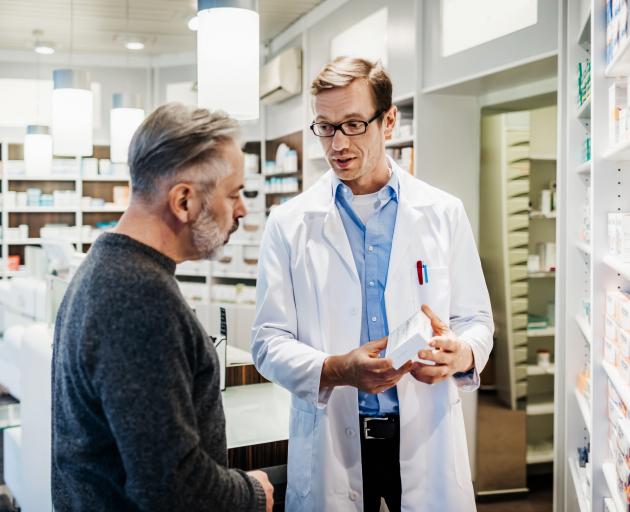 A pharmacist advises a customer about his prescription. Photo: Getty Images 