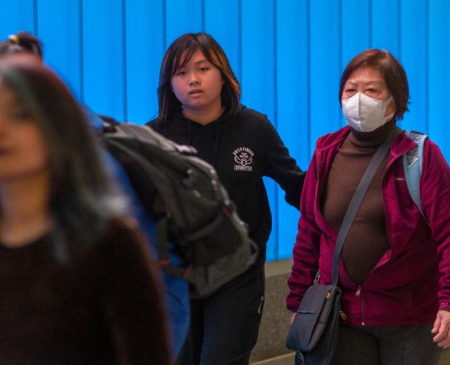 Woman wears mask in Los Angeles airport as coronavirus screening begins. Photo: Getty Images