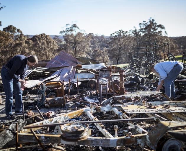 Brian and Elizabeth Blakeman inspect the bushfire damage to their property in Wairewa, Australia,...