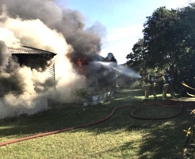 Volunteer firefighters tackle a house fire near Te Anau yesterday. Photo: Te Anau Volunteer Fire...