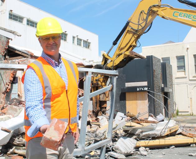 HWCP director Scott O'Donnell holds a brick from a massive demolition task that signals the start...