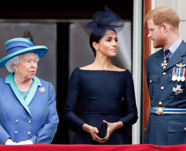 Queen Elizabeth II, Meghan, Duchess of Sussex and Prince Harry, Duke of Sussex watch a flypast to...