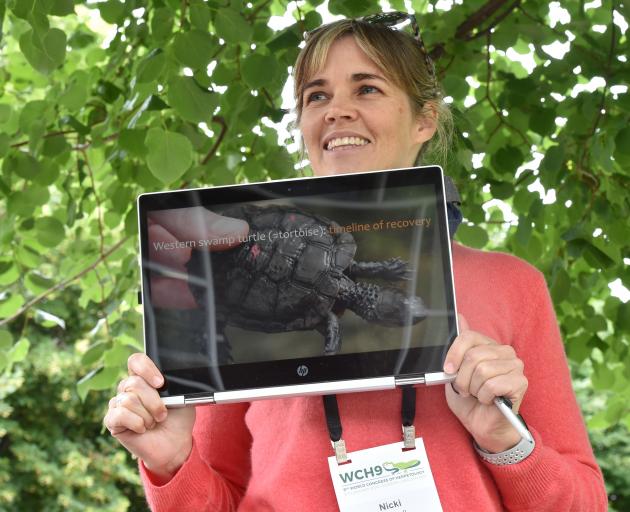Australian researcher Dr Nicki Mitchell holds a photo of the Australian western swamp tortoise. Photo: Gregor Richardson