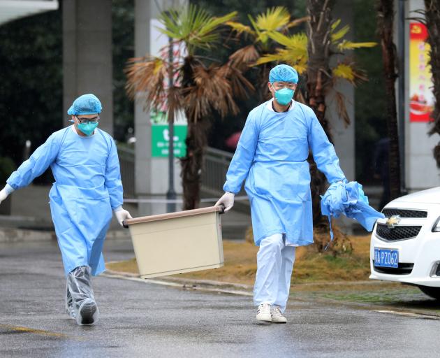 Medical staff carry a box as they walk at the Jinyintan hospital, where the patients with pneumonia caused by the new strain of coronavirus are being treated, in Wuhan. Photo: Reuters