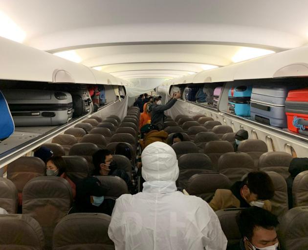 Filipinos voluntarily evacuated due to the coronavirus outbreak, board on a plane from Wuhan,...