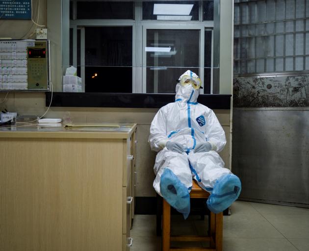 A medical worker takes a break during her night shift at a community health service centre in...
