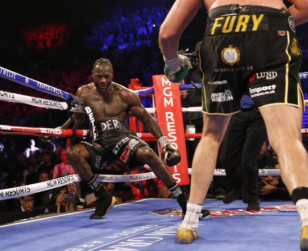 Tyson Fury knocks down Deontay Wilder during the fight. Photo: Reuters