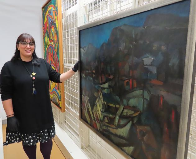 Ashburton Art Gallery curator manager Shirin Khosraviani shows one of the restored paintings.