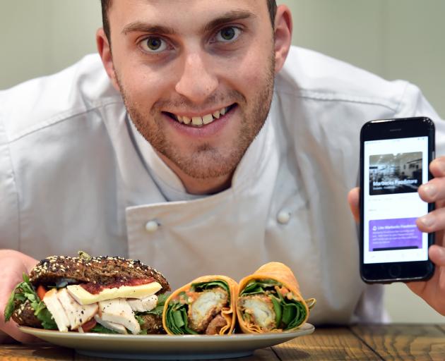 Marbecks Foodstore chef Jean-Baptiste Rousselot with the foodstore’s page on a mobile app, intended to cut food waste. Photo: Peter McIntosh