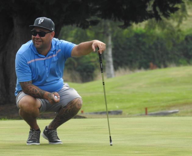 Matt Tautari, of Invercargill, gets ready to line up his putt on the 18th green on Sunday...