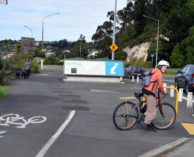 A cyclist waits to cross Portsmouth Dr near the Otago Peninsula map lay­by area on Tuesday. PHOTO: SHAWN MCAVINUE